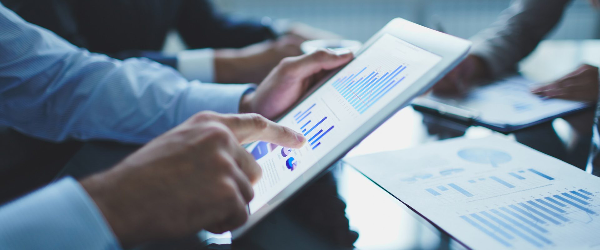 Image of businessperson pointing at document in touchpad at meeting